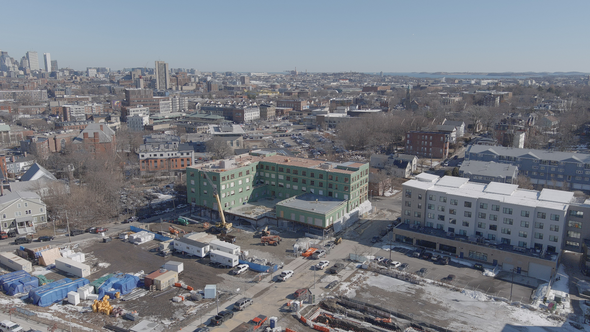 Aerial view of urban commercial construction site with city skyline in the background