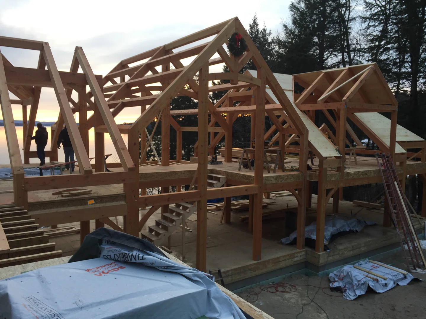 Timber framing under construction at sunset beside Lake Winnipesaukee